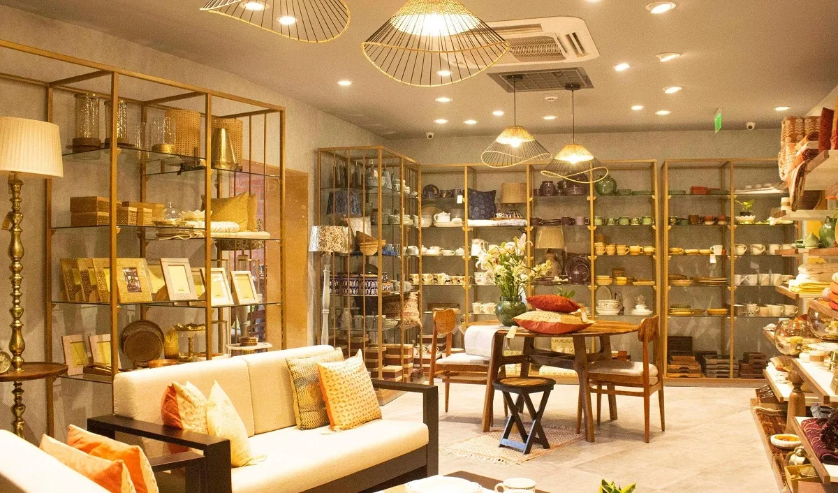 Interior of Fabindia's first Home & Lifestyle store in Delhi showcasing furniture, decor, and tableware in warm lighting.